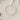 A white ornament with a ribbon, featuring a message that reads "First Christmas as Nanny & Grandad" and "Love Charlie x" printed on it.