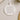 A white ornament with a floral design and text that reads "Our First Christmas Engaged" and " Charlotte & Matthew 28.10.2025".